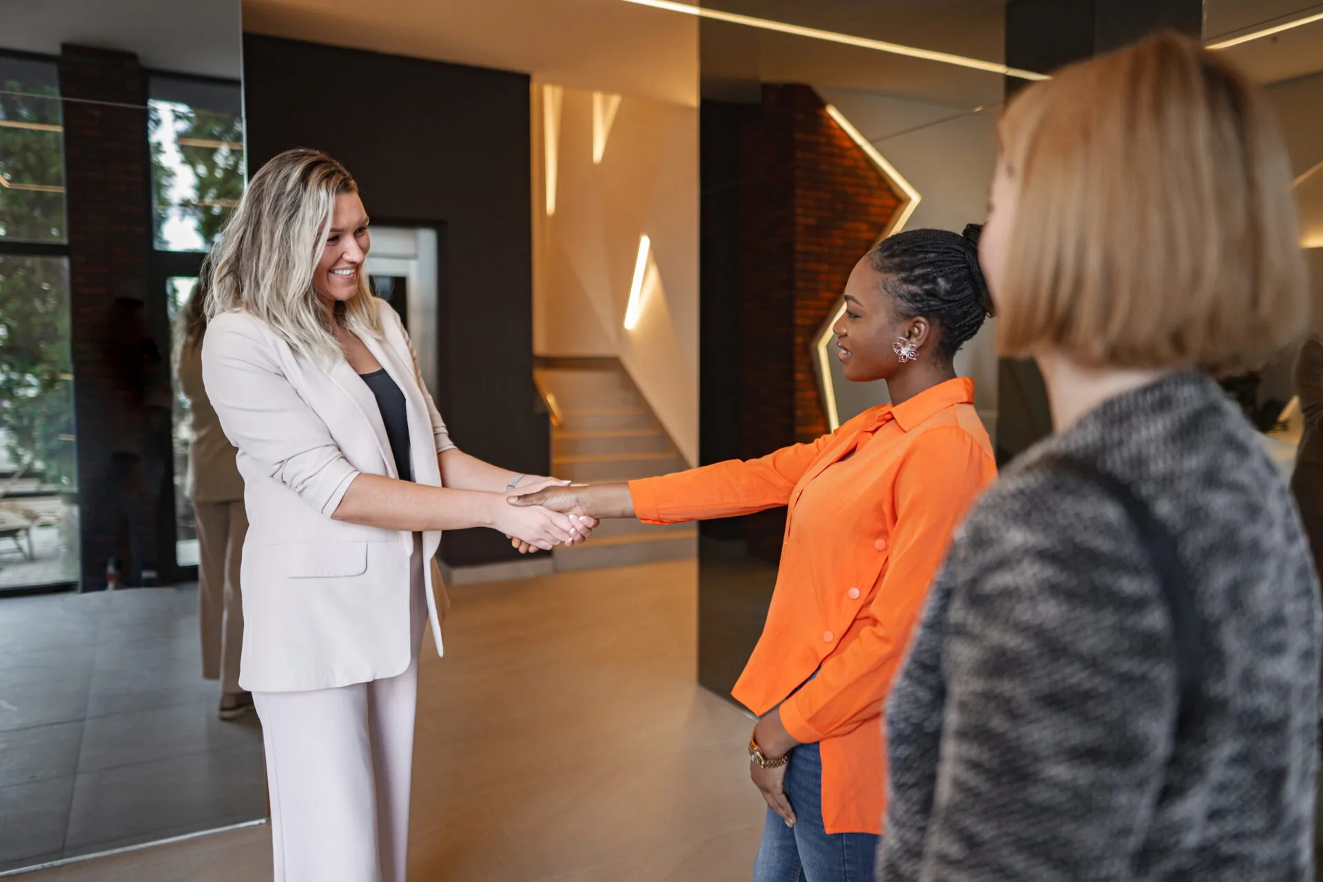 Two happy people shake hands in a modern home setting