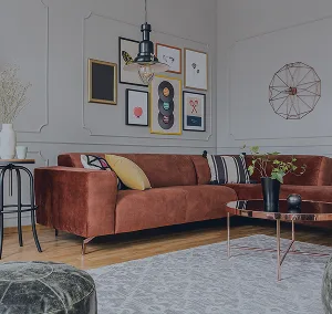 A modern living space with a large orange couch and assorted artwork