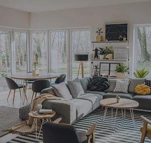 A bright living space with a large couch, cushions, table and chairs, and other furniture