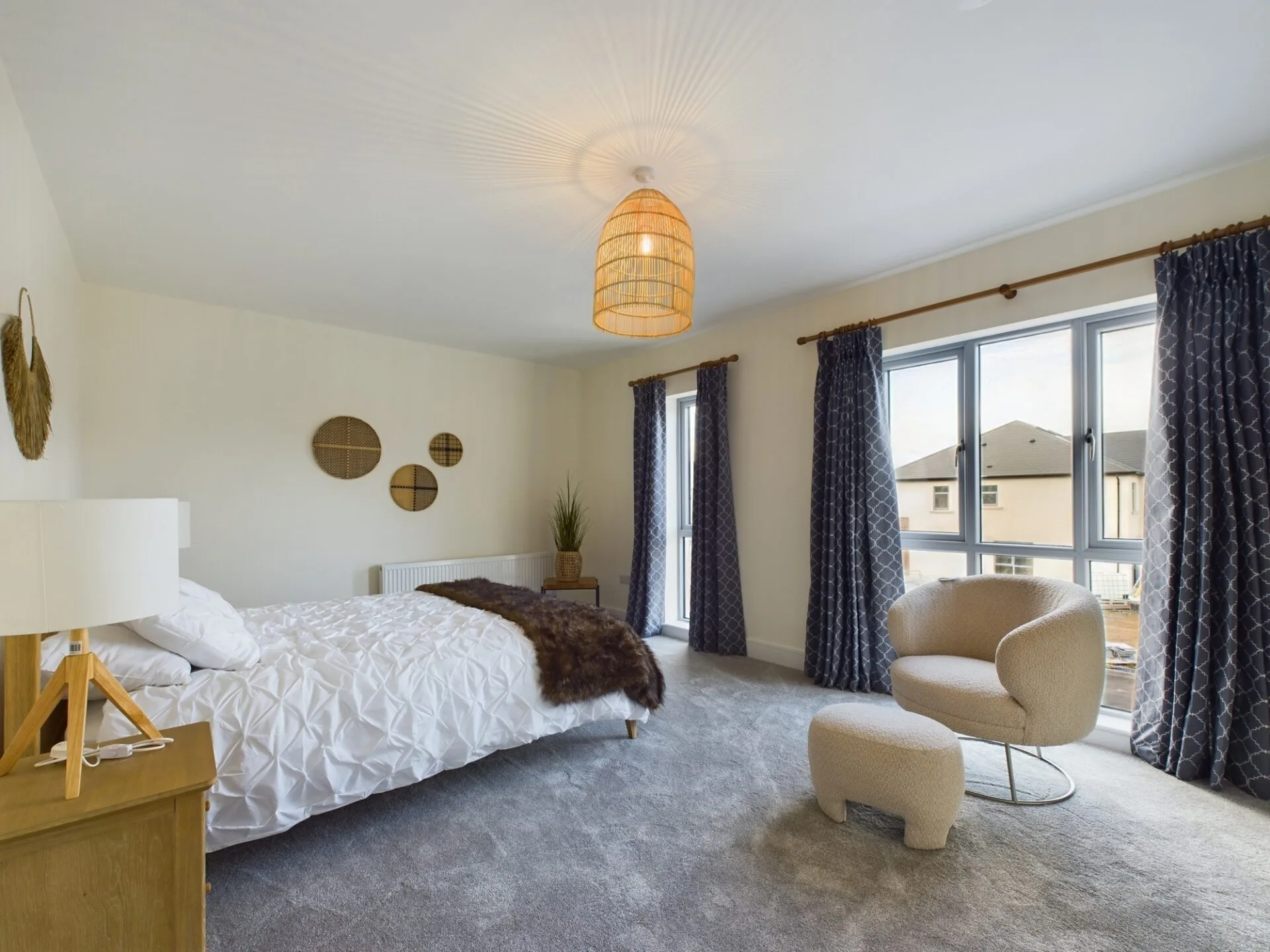 A bright bedroom with modern furniture, big windows and modern lighting