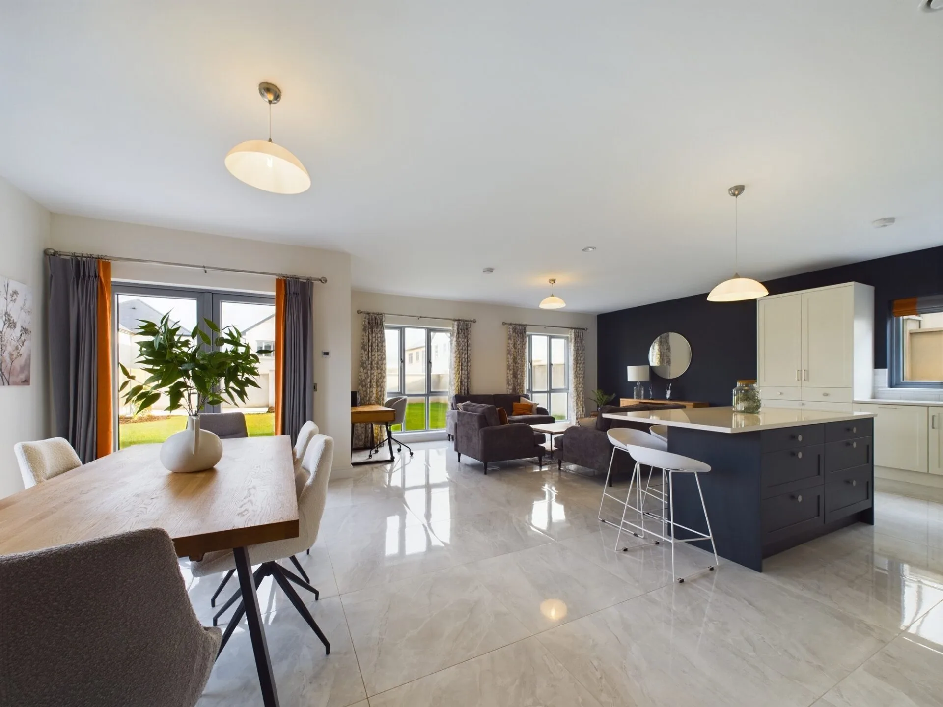 A bright modern kitchen with assorted furniture, bright windows and marble flooring