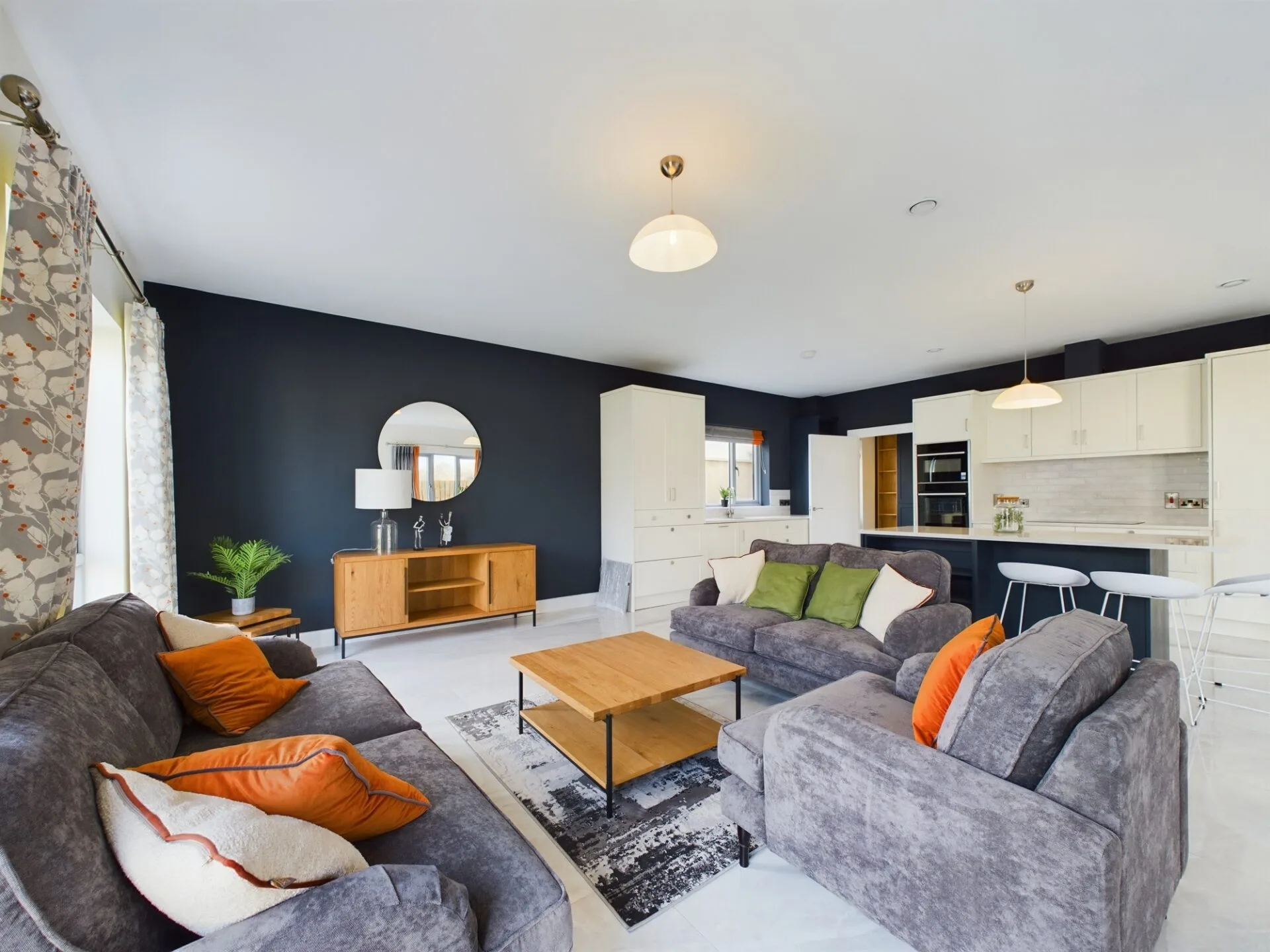 Wide open living room with accompanying kitchen and large couch area