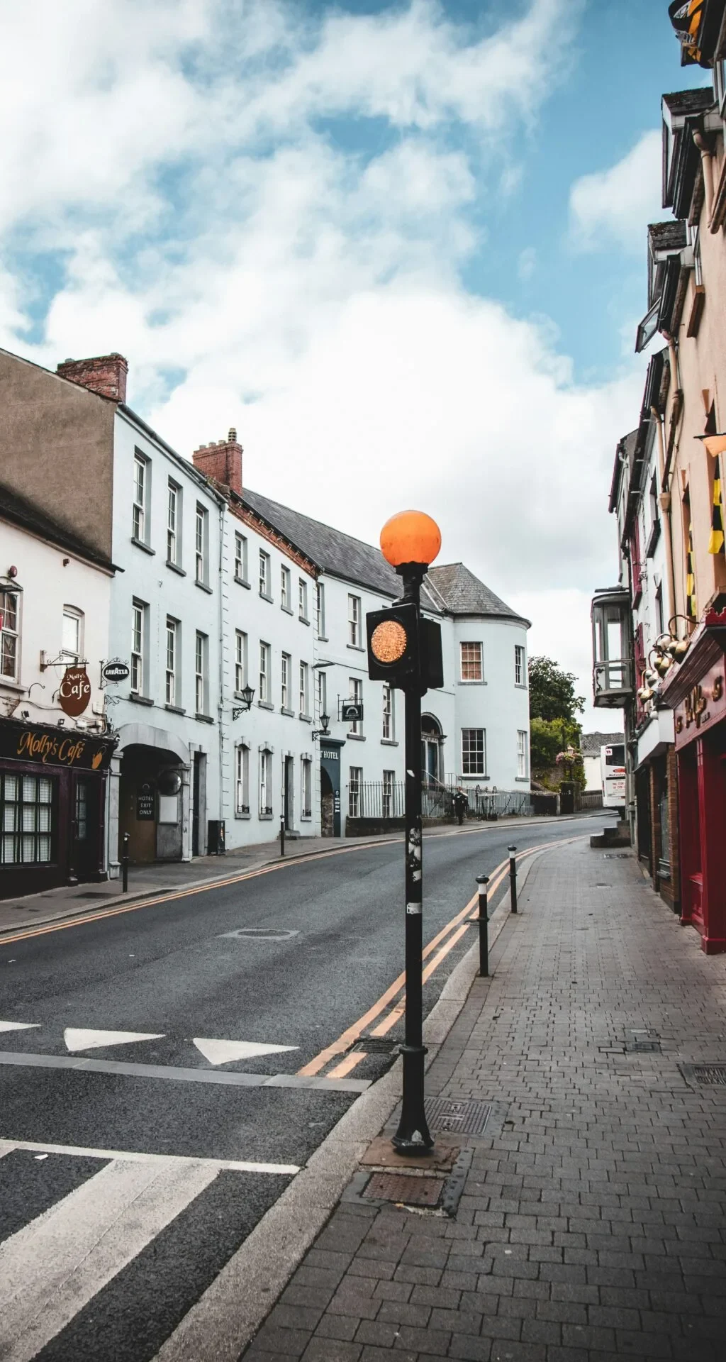 A Kilkenny street with a street lamp, businesses and terraced houses.
